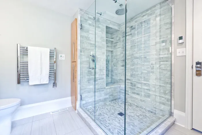 Curbless walk-in shower with glass enclosure in a barrier-free in-law garden suite bathroom